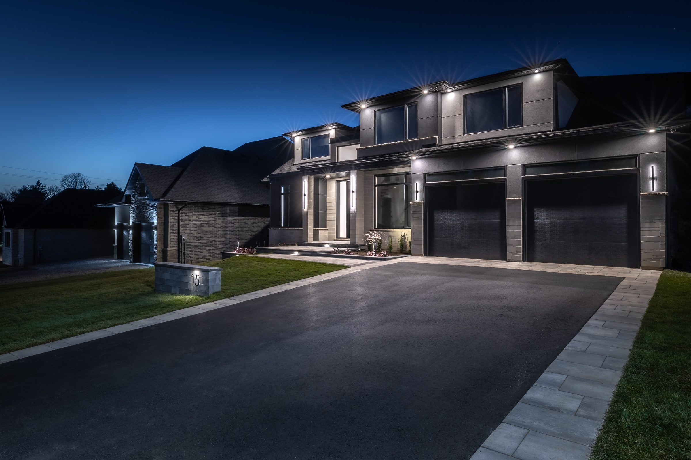 Modern luxury home exterior with landscape lighting — Devine Image
